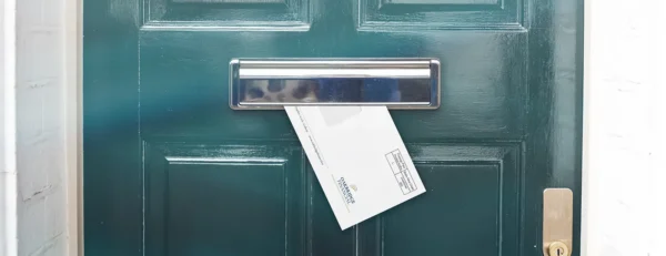 Direct mail envelope being delivered through a letterbox